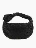 Black braided vegan leather crossbody bag with woven pattern and loop handle.