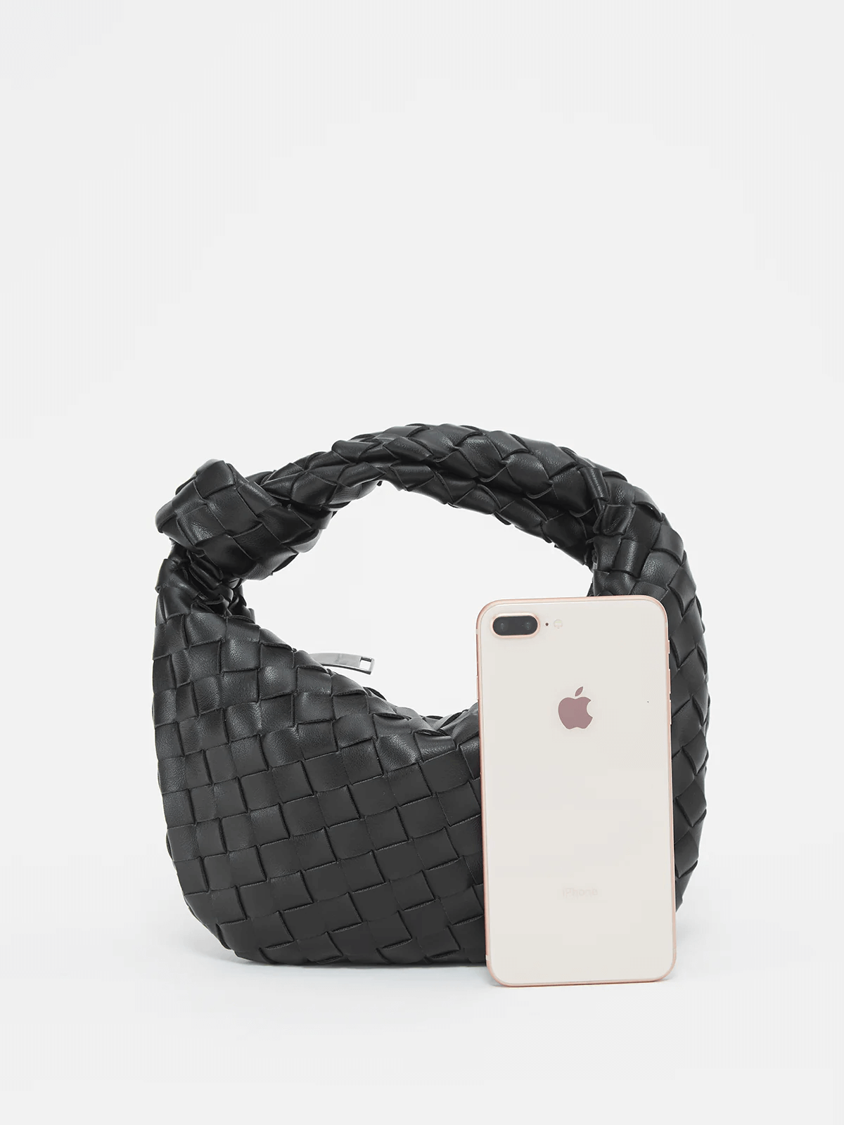 Black braided vegan leather crossbody bag with wide opening, phone placed inside.