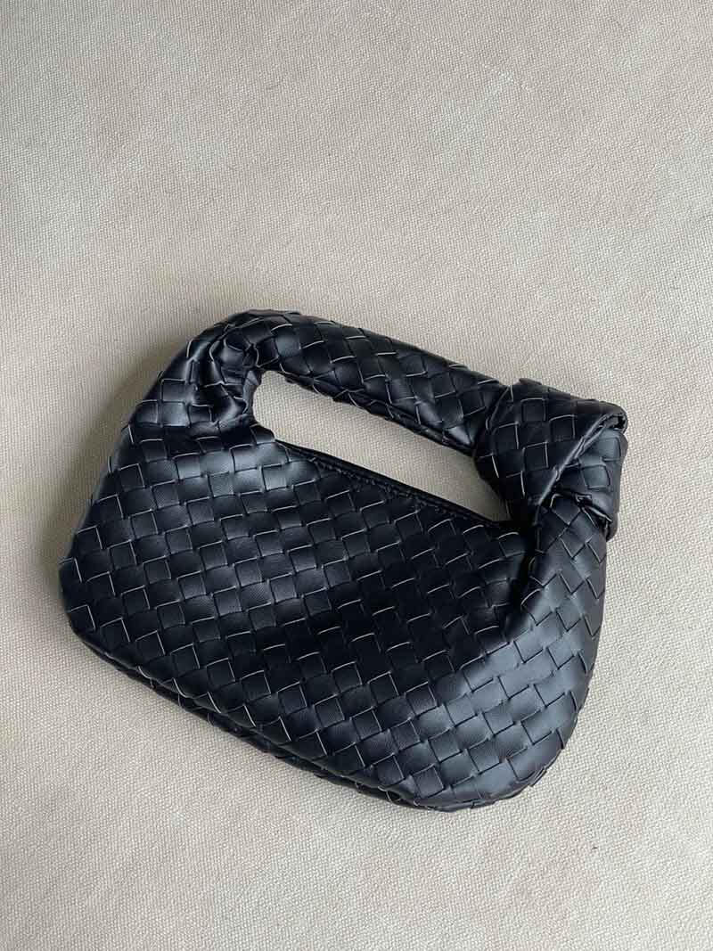 Dark blue braided vegan leather crossbody bag with woven pattern and loop handle.