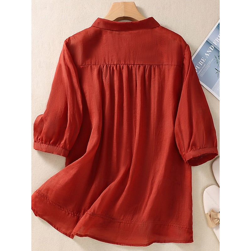 Rust red embroidered blouse with gathered back and loose-fit 3/4 sleeves on hanger