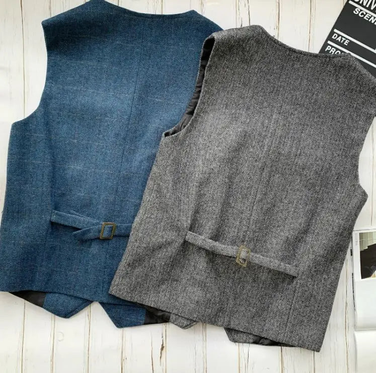 Men's blue and gray sleeveless vests laid flat, V-neck with button front and belt loop