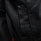 Black leather motorcycle-style jacket close-up of vertical seam panels and stitching.