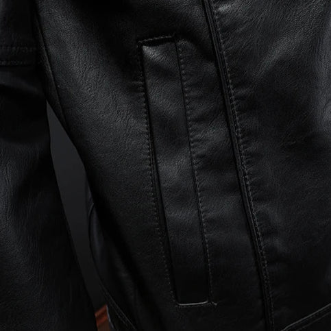 Black leather motorcycle-style jacket close-up of vertical seam panels and stitching.