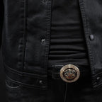 Black leather motorcycle-style jacket close-up with snap buttons and decorative belt buckle.