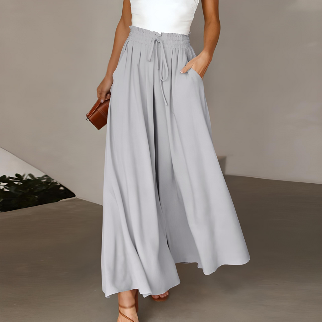 White high-waisted wide-leg trousers with elastic drawstring waist and pleated drape