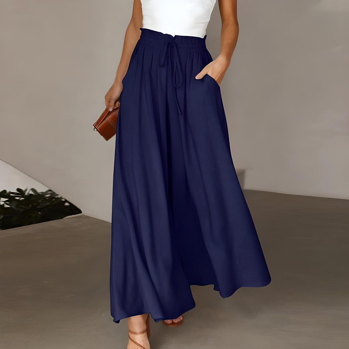 Navy high-waisted wide-leg trousers with elastic drawstring waist and flowing pleated legs
