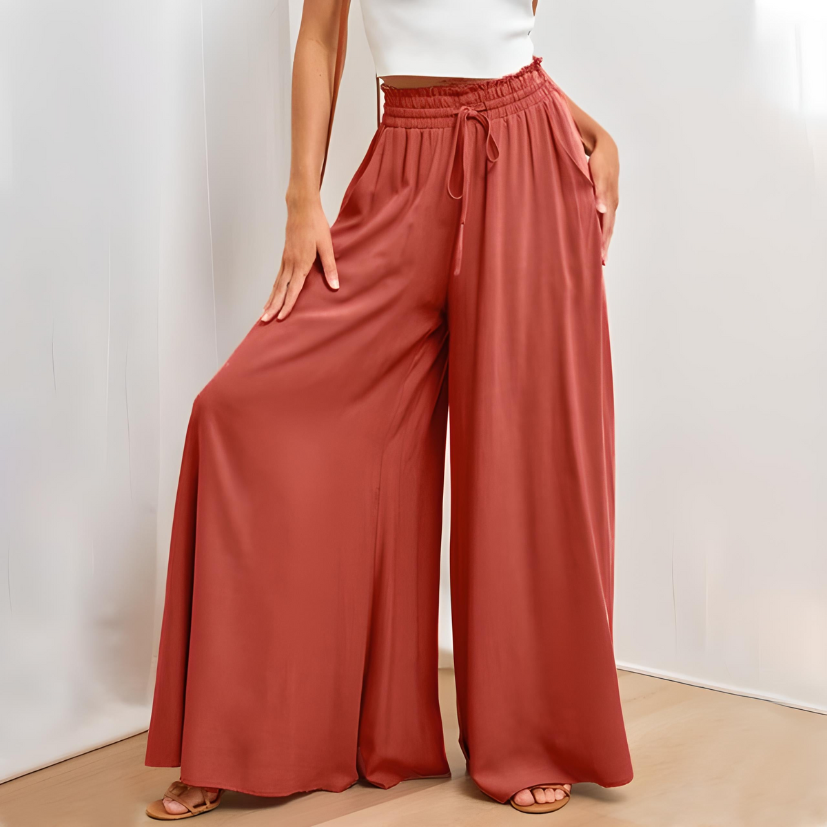 Rust red high-waisted wide-leg trousers with elastic drawstring waist and wide flowing legs