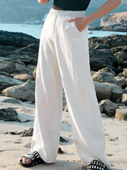White wide-leg linen trousers with elastic waistband, draped wide legs