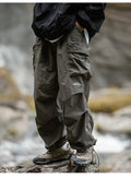 Army green relaxed cargo trousers with multiple flap pockets and cuffed hems