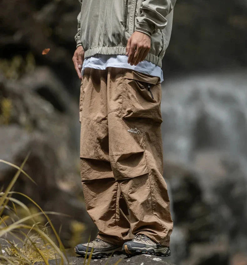 Brown relaxed cargo trousers with large side flap pockets and elastic ankle cuffs