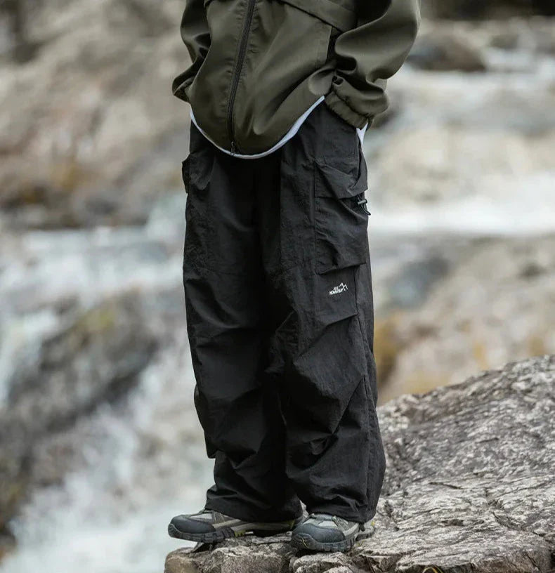 Black relaxed cargo trousers with side cargo pockets and adjustable cuff hems