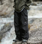 Black relaxed cargo trousers with side cargo pockets and adjustable cuff hems