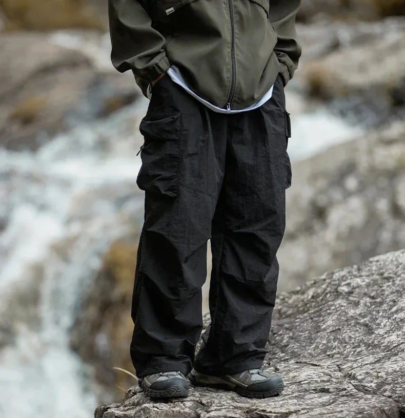 Black relaxed cargo trousers with flap cargo pocket and drawstring cuff detail