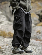 Black relaxed cargo trousers with multiple flap pockets and gathered ankle cuffs