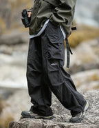 Black relaxed cargo trousers with side utility pockets and strap detail at pocket