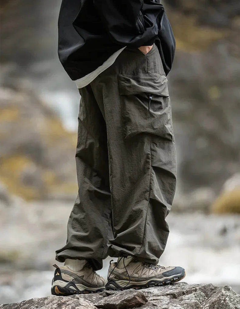 Dark army green relaxed cargo trousers with cargo flap pockets and ankle cuff ties