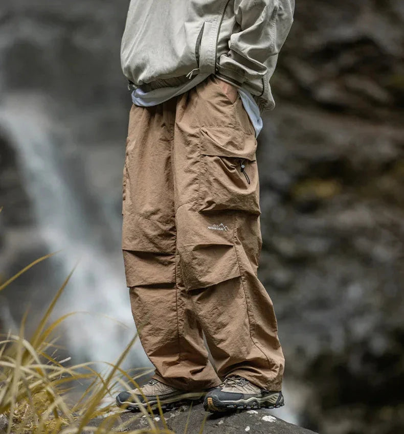 Brown relaxed cargo trousers with flap cargo pockets and elastic ankle cuffs