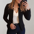 Black blazer with notched lapels and tailored fit, worn over a V-neck top