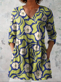 Long V-neck blouse with 3/4 sleeves, green and blue abstract floral print, button trim