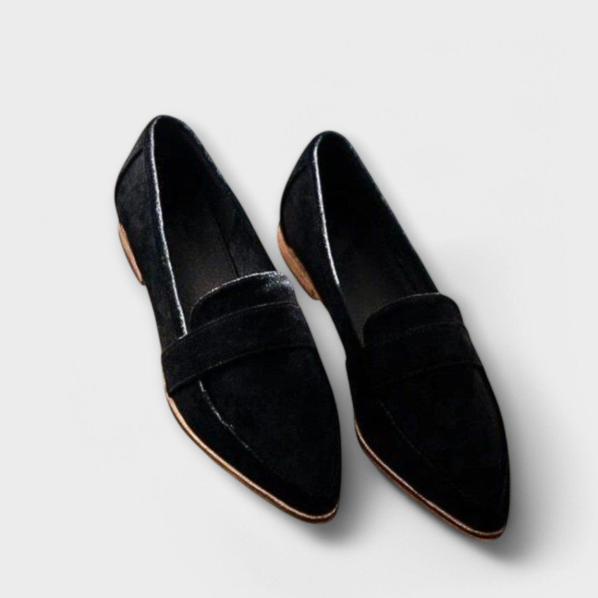 Black suede slip-on loafers with wide strap and tan-edged sole.