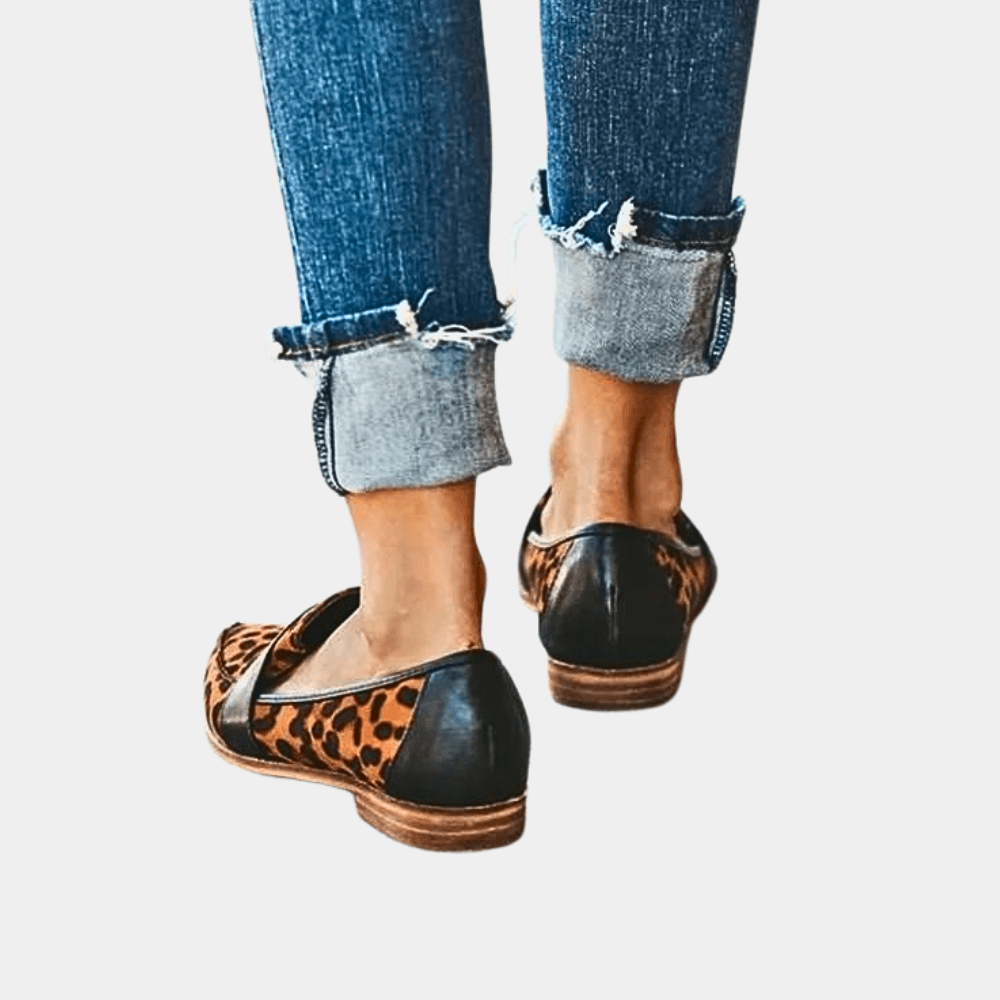 Leopard print slip-on loafers with black strap and pointed toe; tan sole.