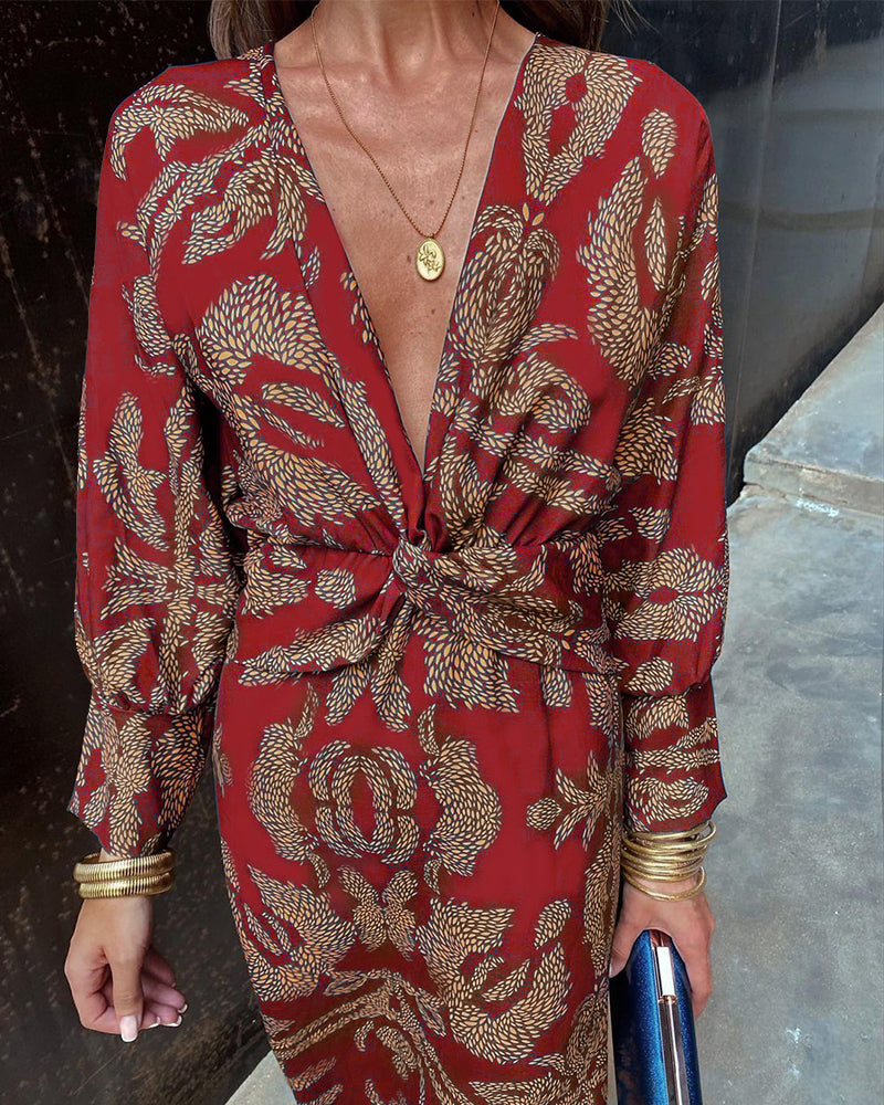Red patterned V-neck midi dress with gathered tie waist and long sleeves with cuff trim.