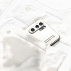 White jacket chest pocket holding a smartphone and close-up stitching