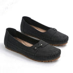 Black suede loafers with round toe, moc stitching, and hook-and-eye strap