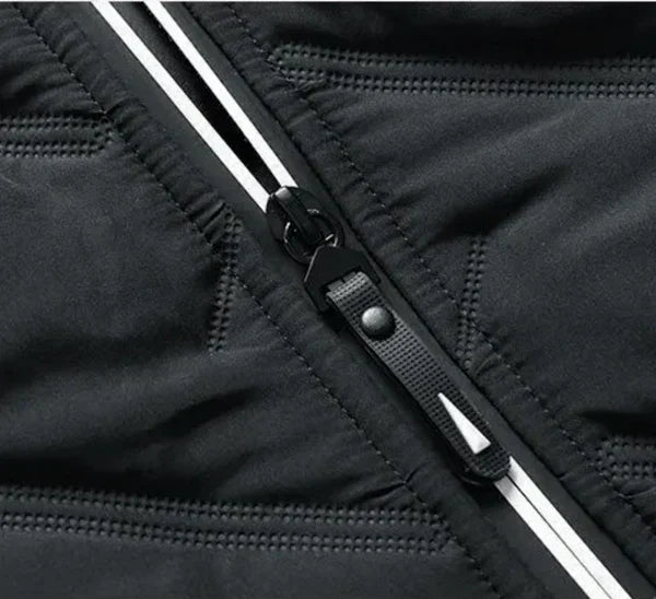 Close-up of black puffer jacket zipper and stitched quilting channels on the front.