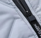 Close-up of zipper pull and stitched quilted panels on a light puffer jacket.