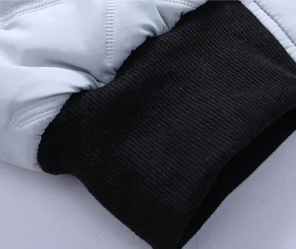 Rib-knit black cuff with light puffer jacket sleeve hem and quilted stitching.