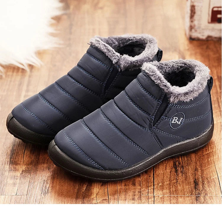 Navy winter slip-on boots with gray faux-fur lining, padded stripes, and side logo