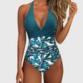 Teal halter one-piece swimsuit with ruched waist and tropical leaf print
