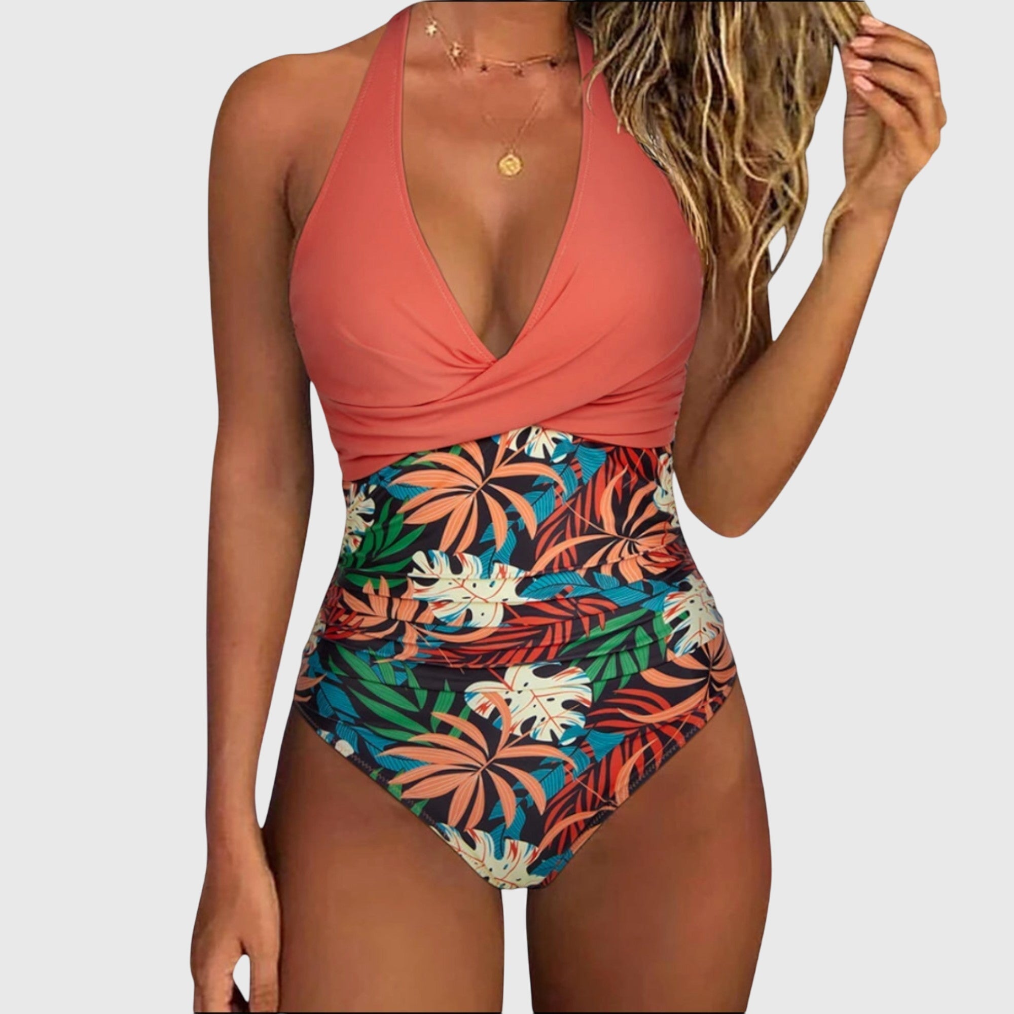 Coral halter one-piece swimsuit with ruched waist and tropical leaf print