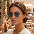 Cat-eye sunglasses with gold-tone metal frame and rhinestone temple detail on dark lenses