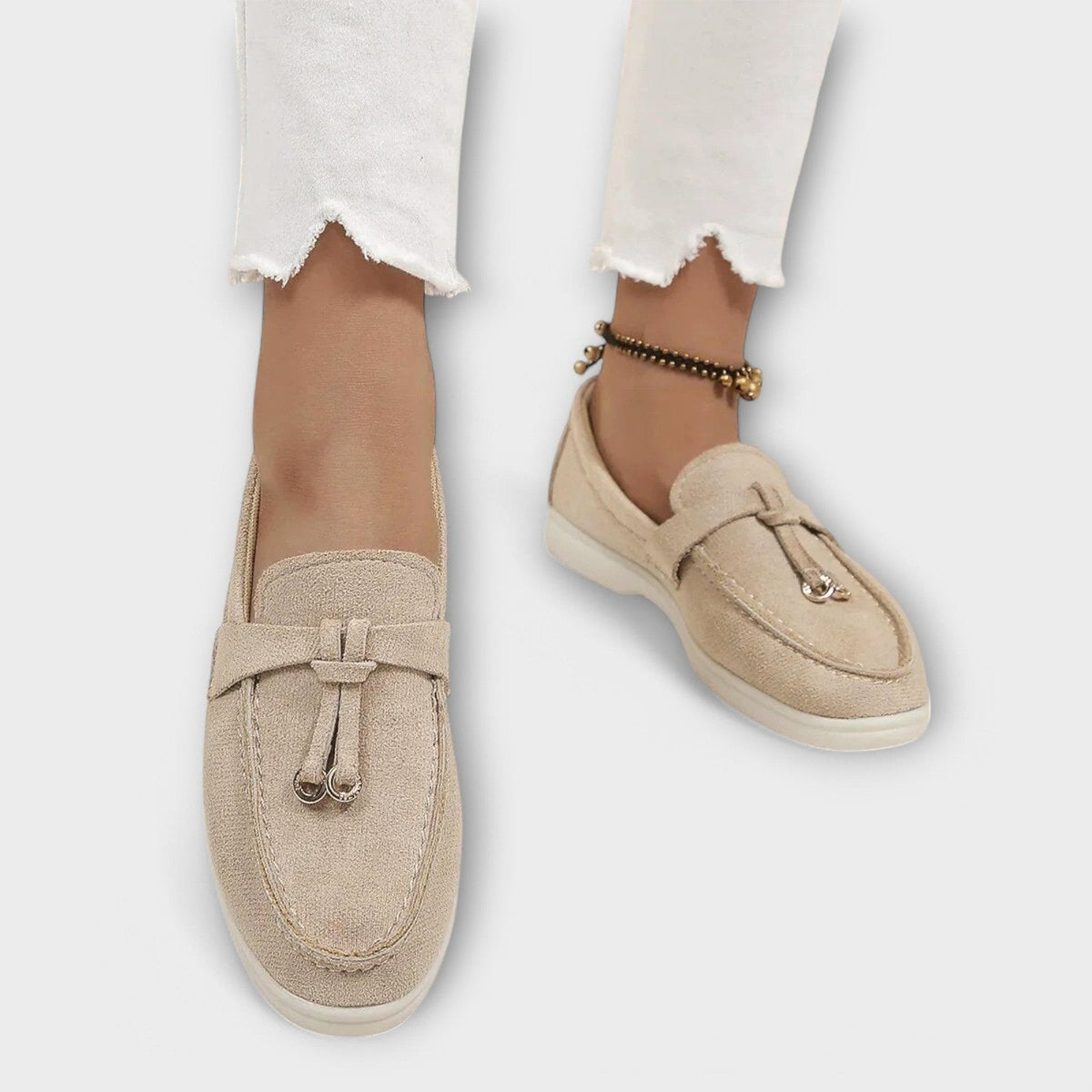 Women's beige suede slip-on loafers with bowknot vamp detail and stitched seams