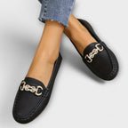 Women's lightweight leather loafer, black angled side view with gold buckle detail