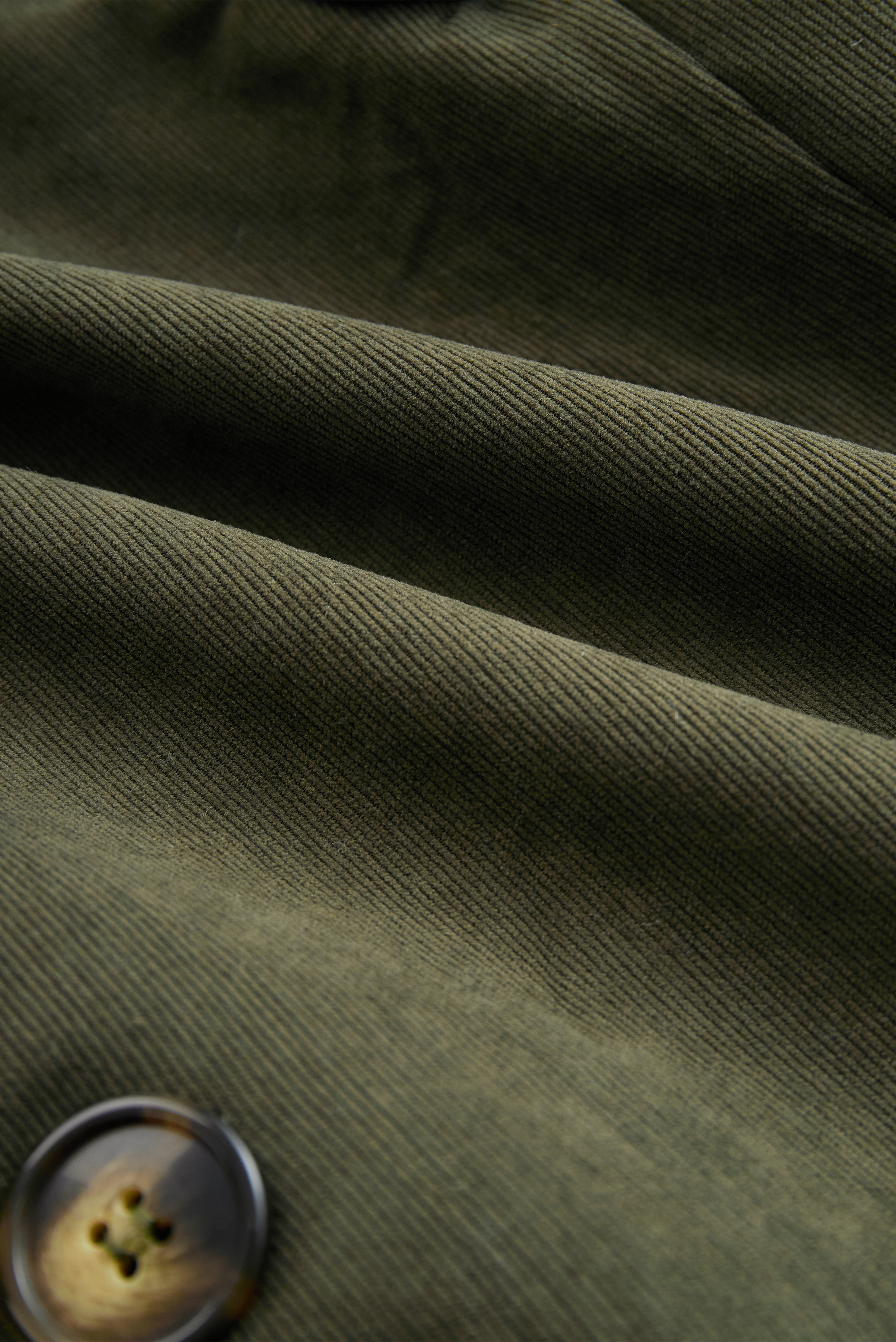 Military green corduroy jacket fabric close-up with fine ribbed texture
