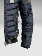 Men's navy quilted jacket close-up of sleeve cuff and zip pocket