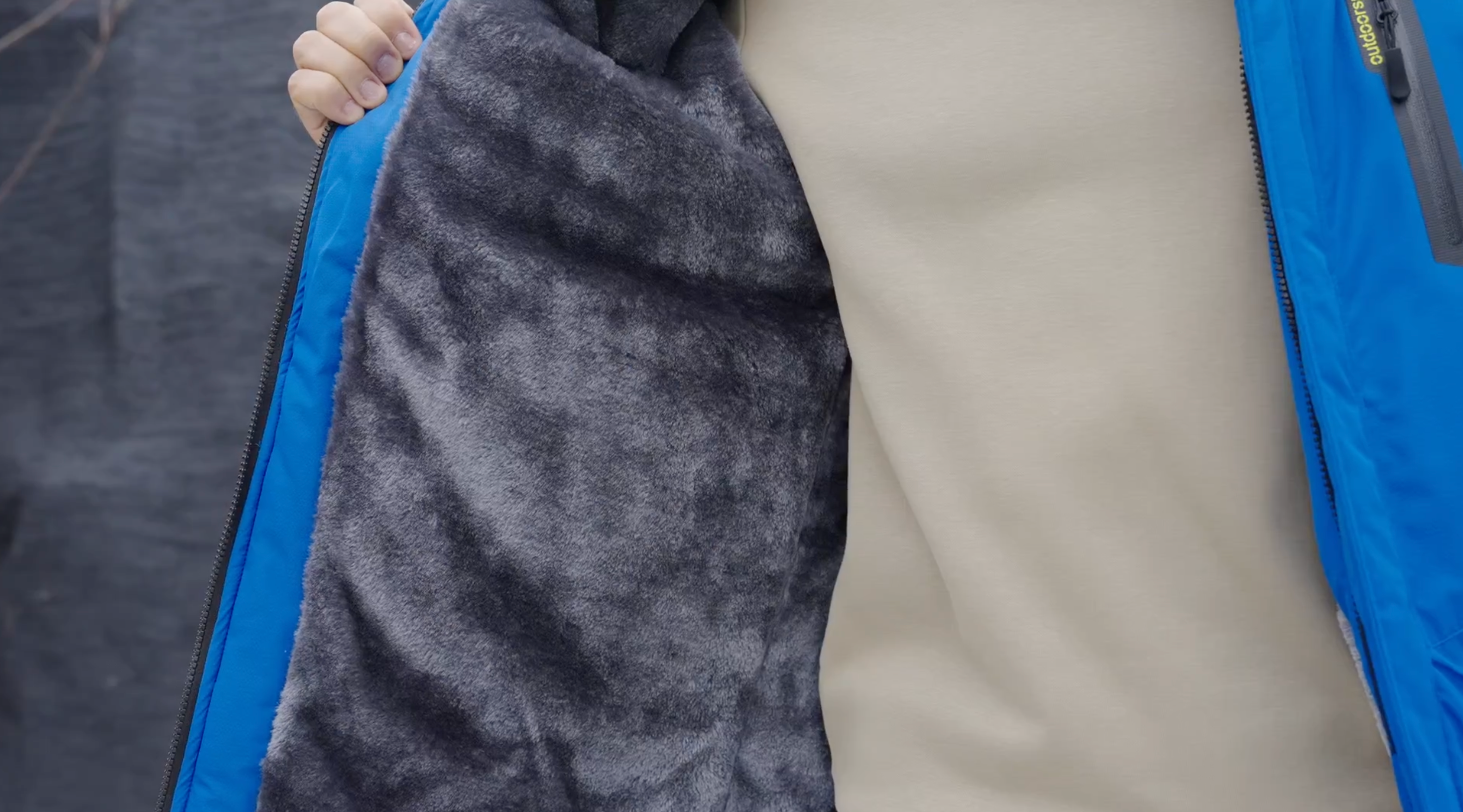 Blue winter jacket lining close-up with gray fleece interior panel.