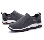 Men's dark gray slip-on hiking shoes with padded collar, white sole, and orange tread