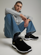 Men's black hiking shoes with low-profile slip-on design and white sole with orange tread