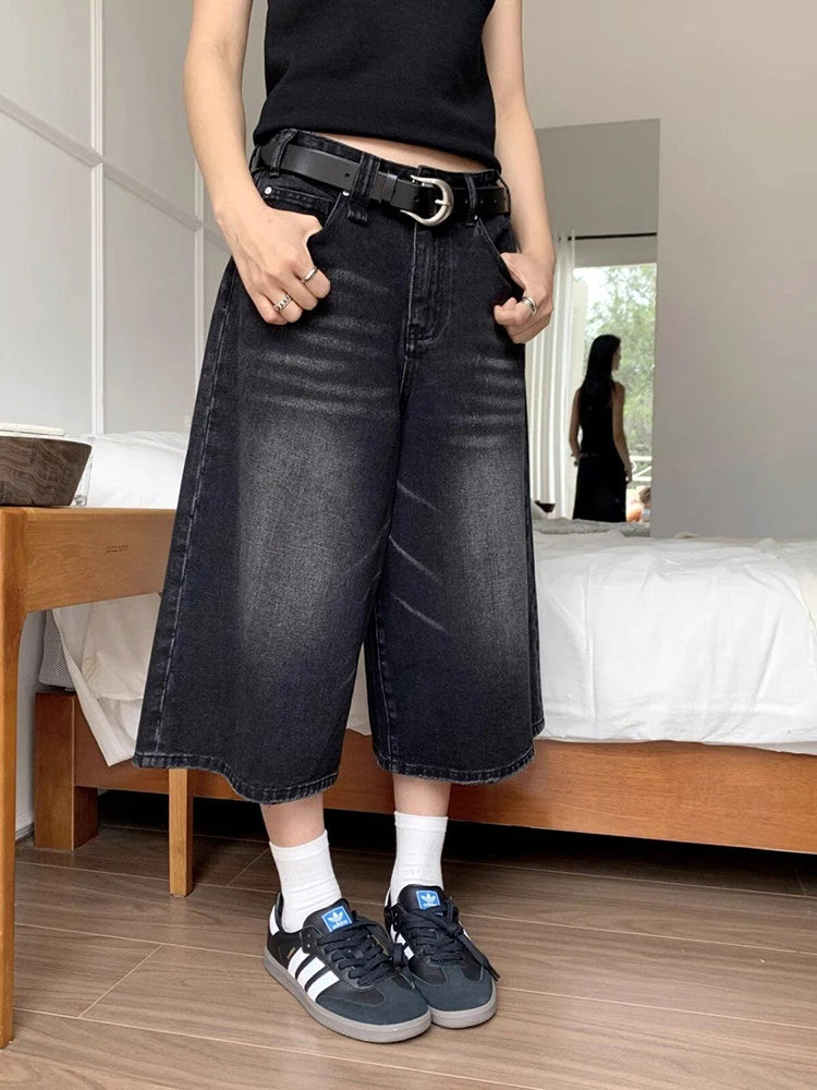 Black high-waisted wide-leg denim culottes with belt loops and front closure
