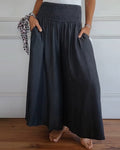 High-waisted wide-leg trousers with smocked elastic waistband, dark charcoal.
