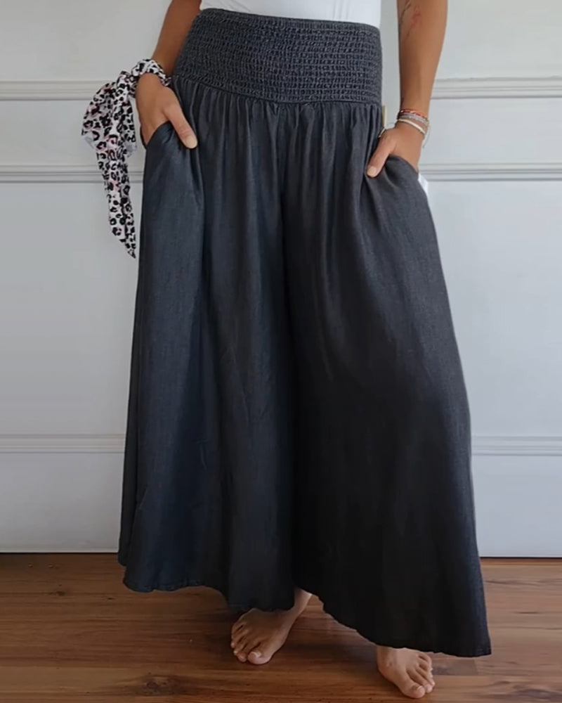 High-waisted wide-leg trousers with smocked elastic waistband, dark charcoal.
