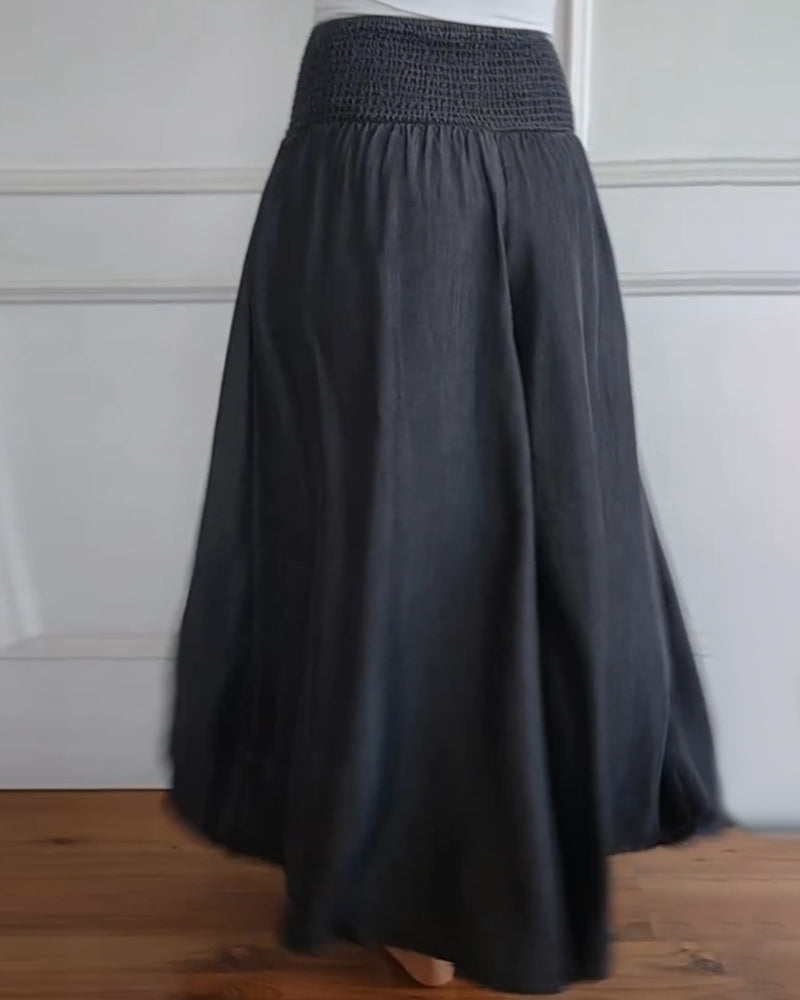 High-waisted wide-leg trousers with smocked elastic waistband, dark charcoal, back view.