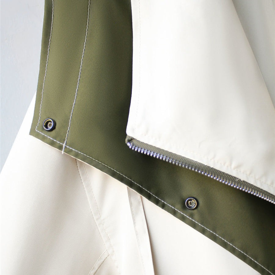 Windbreaker jacket hem with stitched button tabs and contrast olive trim over cream