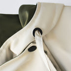 Windbreaker jacket collar with black toggle drawstring on cream and olive panels