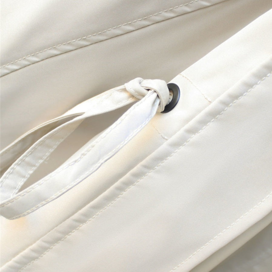 Windbreaker jacket sleeve drawstring with black-tipped cord on cream fabric