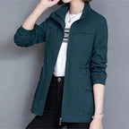 Dark teal high-neck full-zip jacket with chest pockets and ribbed cuffs